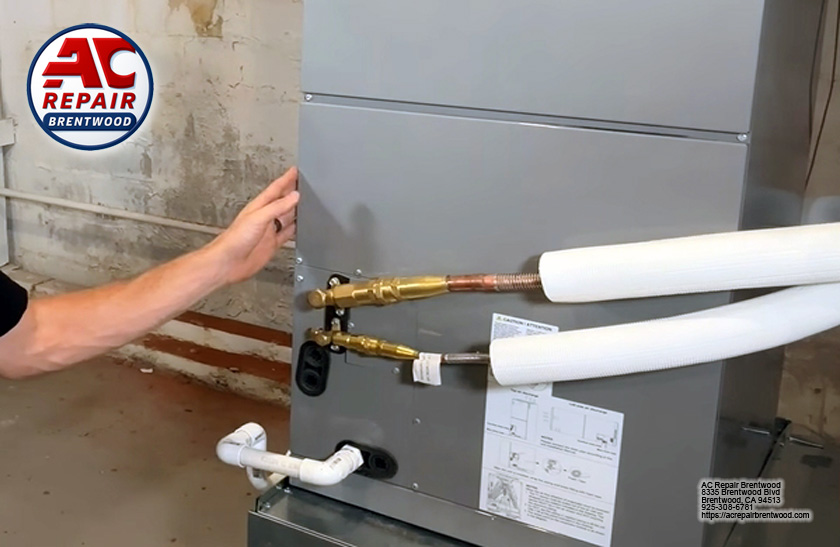 Technician connecting refrigerant lines during heat pump installation in Discovery Bay