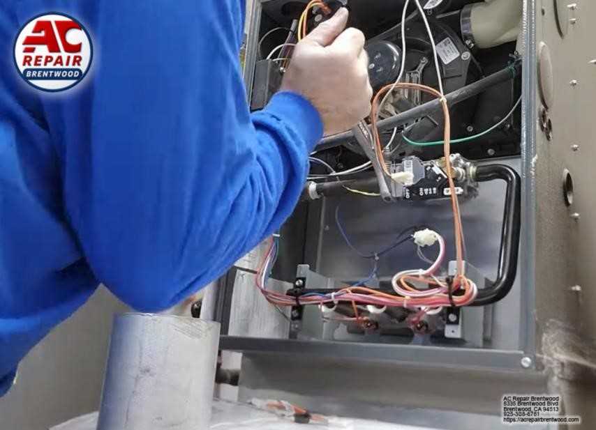 Professional heating technician servicing a furnace in Brentwood