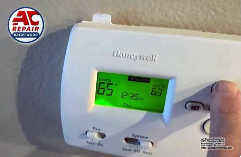 Technician programming digital thermostat during replacement service