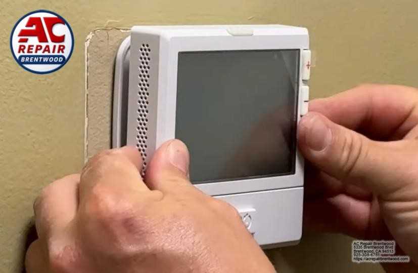 AC technician replacing a thermostat in Brentwood, CA